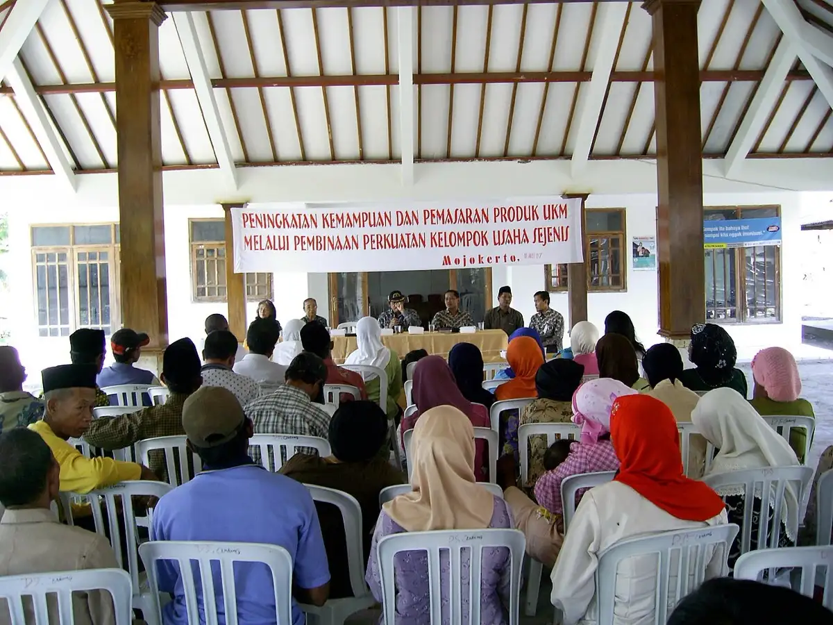 Rapat di balai desa sebagai ilustrasi musyawarah pembagian SHU koperasi.